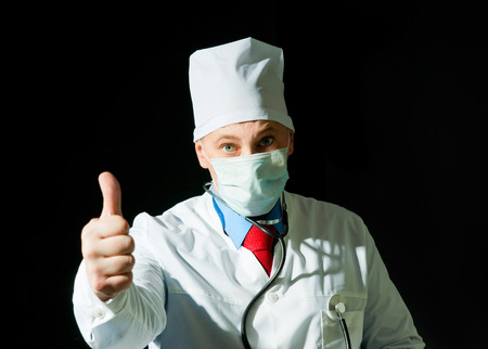 Portrait of doctor in surgical mask on black の写真素材
