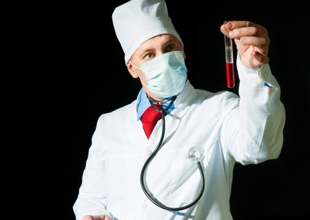 Doctor in surgical mask holding the vialの写真素材