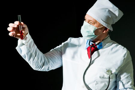 Doctor in surgical mask holding the vialの写真素材
