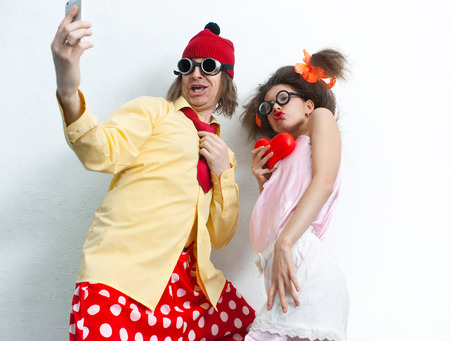 Bizarre couple in love is photographed on a mobile phoneの写真素材