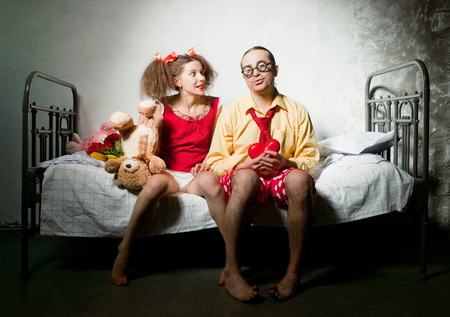 Funny couple sitting on the bedの写真素材