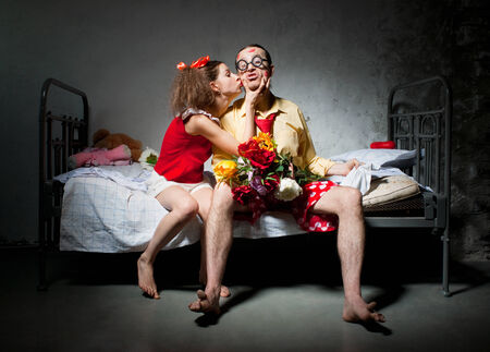 Funny couple sitting on the bedの写真素材