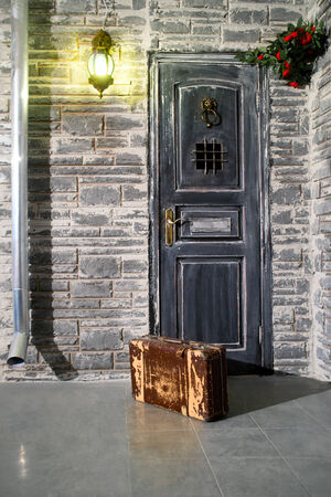 Old brown suitcase at the doorの写真素材