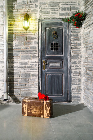Old suitcase at the door and flower in the handle of doorの写真素材