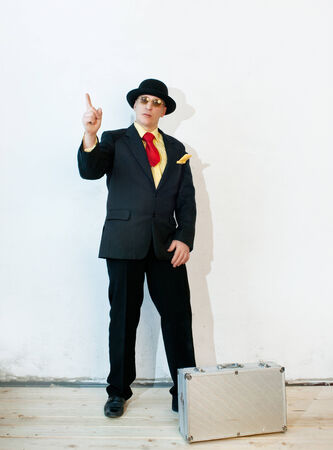 Businessman in black suit with a suitcaseの写真素材