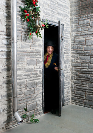 Cautious man peeping from behind the door の写真素材