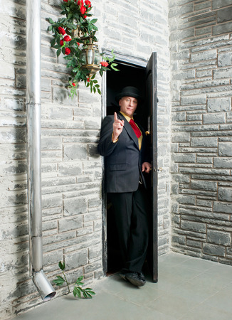 Cautious man peeping from behind the doorの写真素材