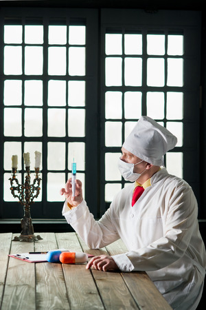 Doctor in the mask sitting at a tableの写真素材