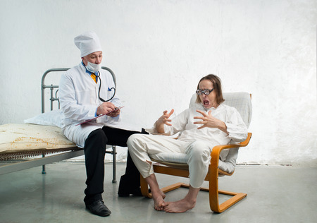 Doctor and crazy patient in a hospitalの写真素材
