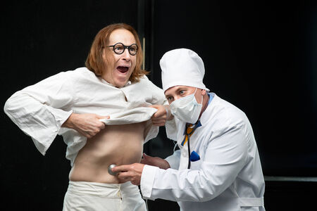 Doctor listens to a stethoscope the patientの写真素材