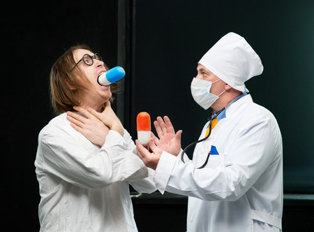 Patient takes the pill out of the hands of the doctorの写真素材