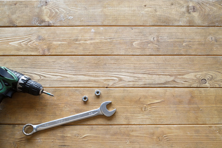 Spanner wrench, screwdriver and nuts on the wooden backgroundの写真素材