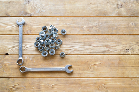 Wrenches and nuts on the wooden backgroundの写真素材