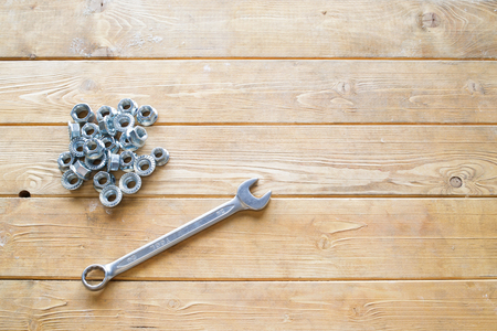 Spanner wrench and nuts on the wooden backgroundの写真素材