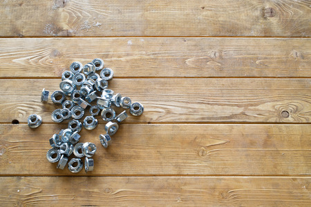 Metal nuts on the wooden background
