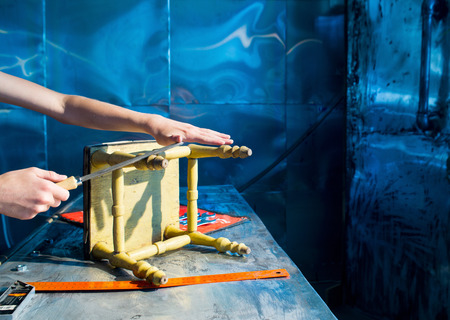 Carpenter repairing the stool in the workshopの写真素材