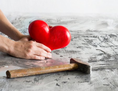 Shaken heart with hands and hammerの写真素材