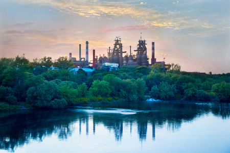 Metallurgical works on the background of trees and riverの写真素材