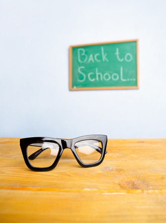 Teacher glasses on the table in the classroomの写真素材