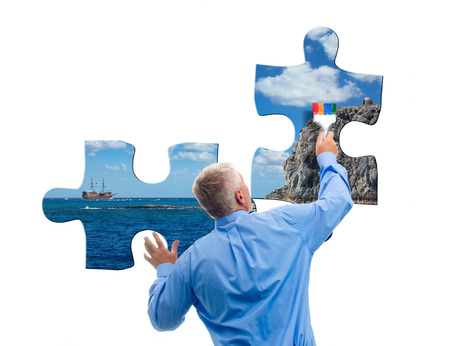 Man collects jigsaw puzzles with sea viewの写真素材