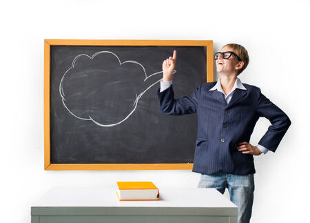 Cheerful pupil stands at the blackboardの写真素材