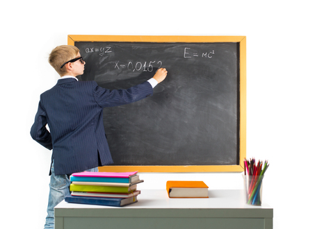 Schoolboy solves the problem on the blackboardの写真素材