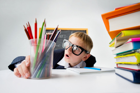 Amazed look of schoolboy sitting at the deskの写真素材