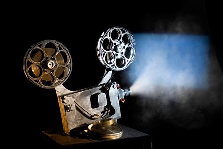 Movie projector with the film on the black backgroundの写真素材