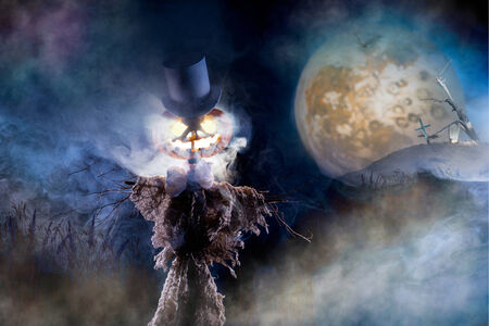 Scarecrow with head of pumpkin on the cemeteryの写真素材