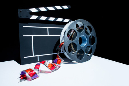 Cinema clapper and reel of film on the black backgroundの写真素材