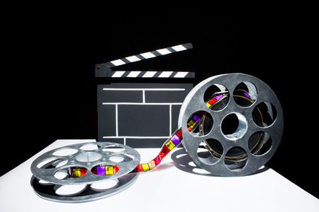 Cinema clapper and reel of film on the black backgroundの写真素材
