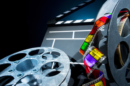Cinema clapper and reels of film on the black backgroundの写真素材
