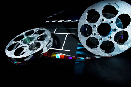 Cinema clapper and reels of film on the black backgroundの写真素材