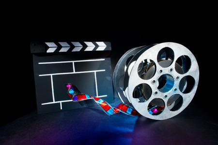Cinema clapper and reels of film on the black backgroundの写真素材