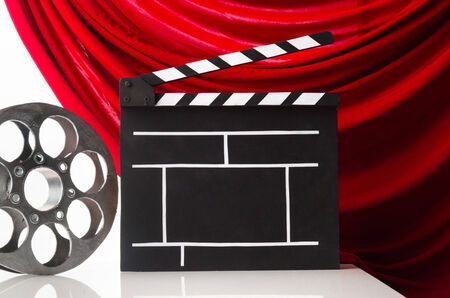 Cinema clapper and reel on the background of red curtainの写真素材
