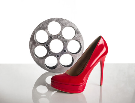 Reel of film and red shoe on a white backgroundの写真素材