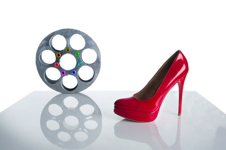 Reel of film and red shoe on a white backgroundの写真素材