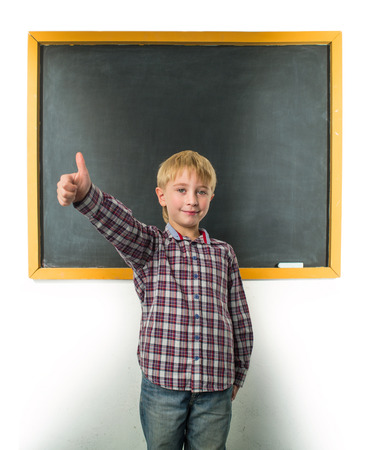 Schoolboy stands at the blackboardの写真素材