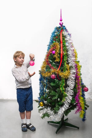Little boy decorates a Christmas treeの写真素材