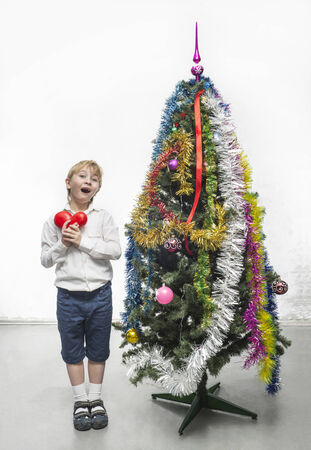 Little boy decorates a Christmas treeの写真素材