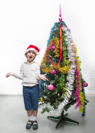 Little Santa near the Christmas treeの写真素材