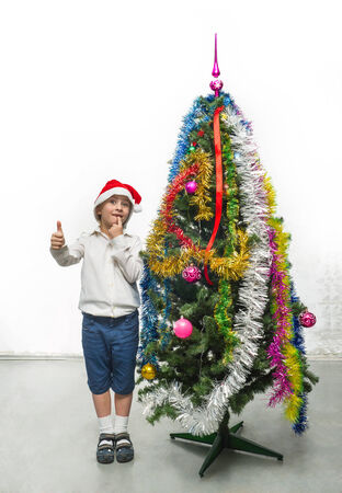 Little Santa near the Christmas treeの写真素材