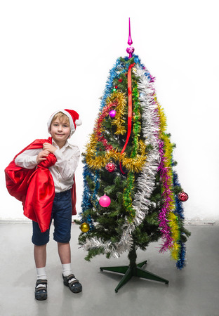 Little Santa with a sack near the Christmas treeの写真素材
