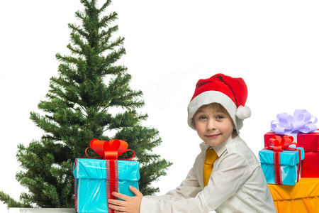 Little Santa with a gift near the Christmas treeの写真素材