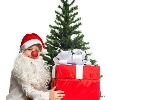 Little Santa with a gift near the Christmas treeの写真素材