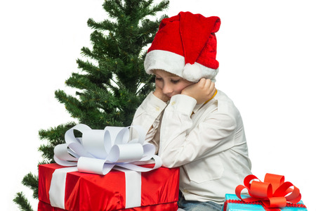 Little Santa with a gift near the Christmas treeの写真素材