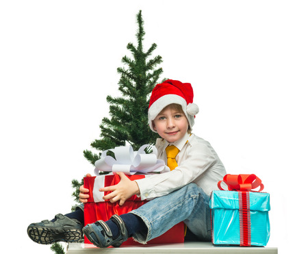 Little Santa with a gift near the Christmas treeの写真素材