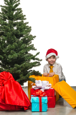 Little Santa with a gift near the Christmas treeの写真素材