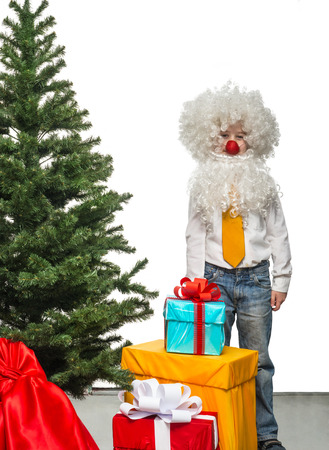 Little Santa with a gift near the Christmas treeの写真素材