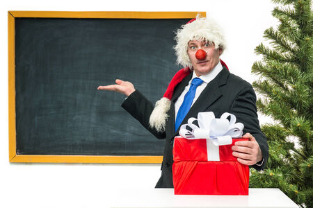 Santa Claus with gifts near the blackboardの写真素材